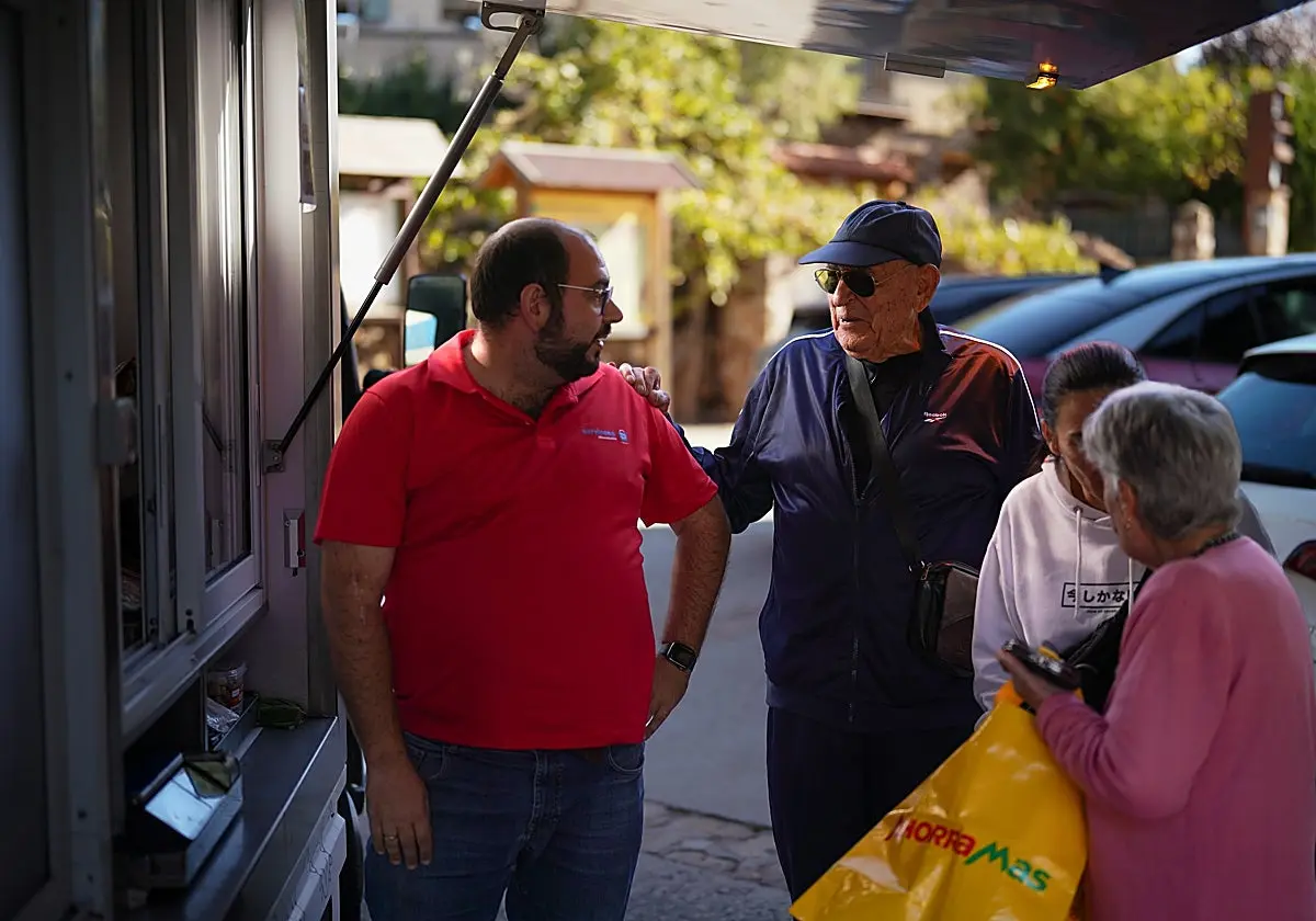 Varios vecinos, entre ellos Restituto «Resti» González (con gorra) acuden a comprar al camión de congelados en Madarcos. Vari