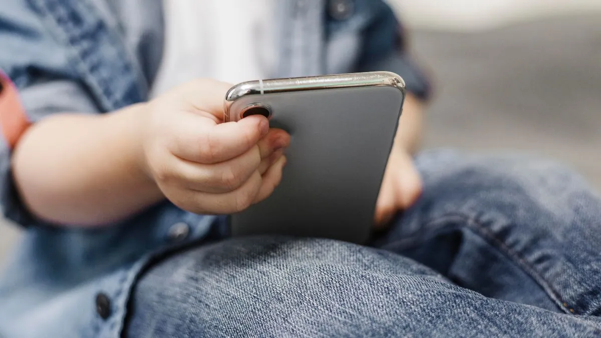 Cataluña limita el uso de pantallas en infantil e impide navegar libremente por internet Un niño utilizando un teléfono móvil