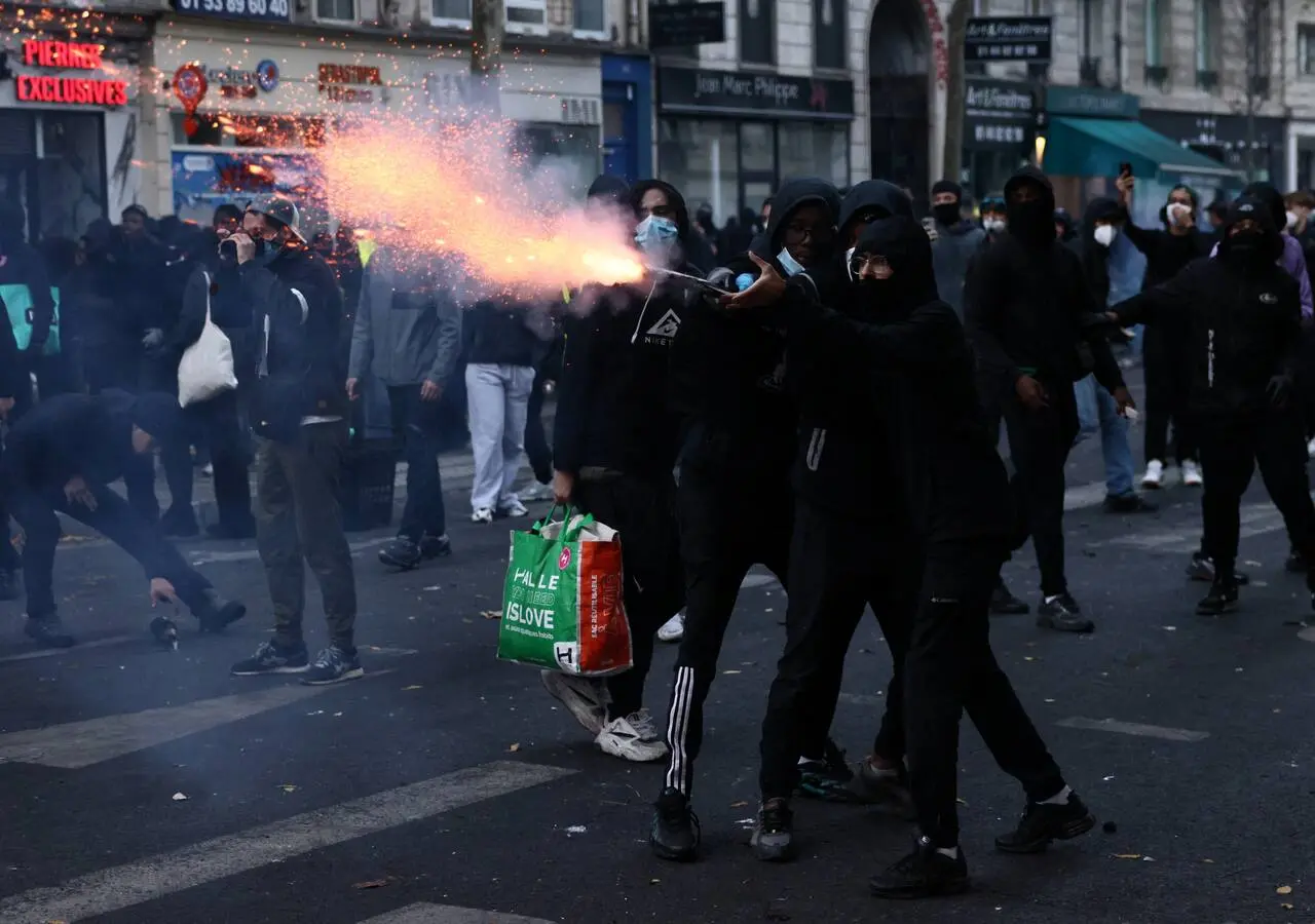 Un manifestante utiliza un petardo en medio de los enfrentamientos que se produjeron durante una jornada de protestas contra