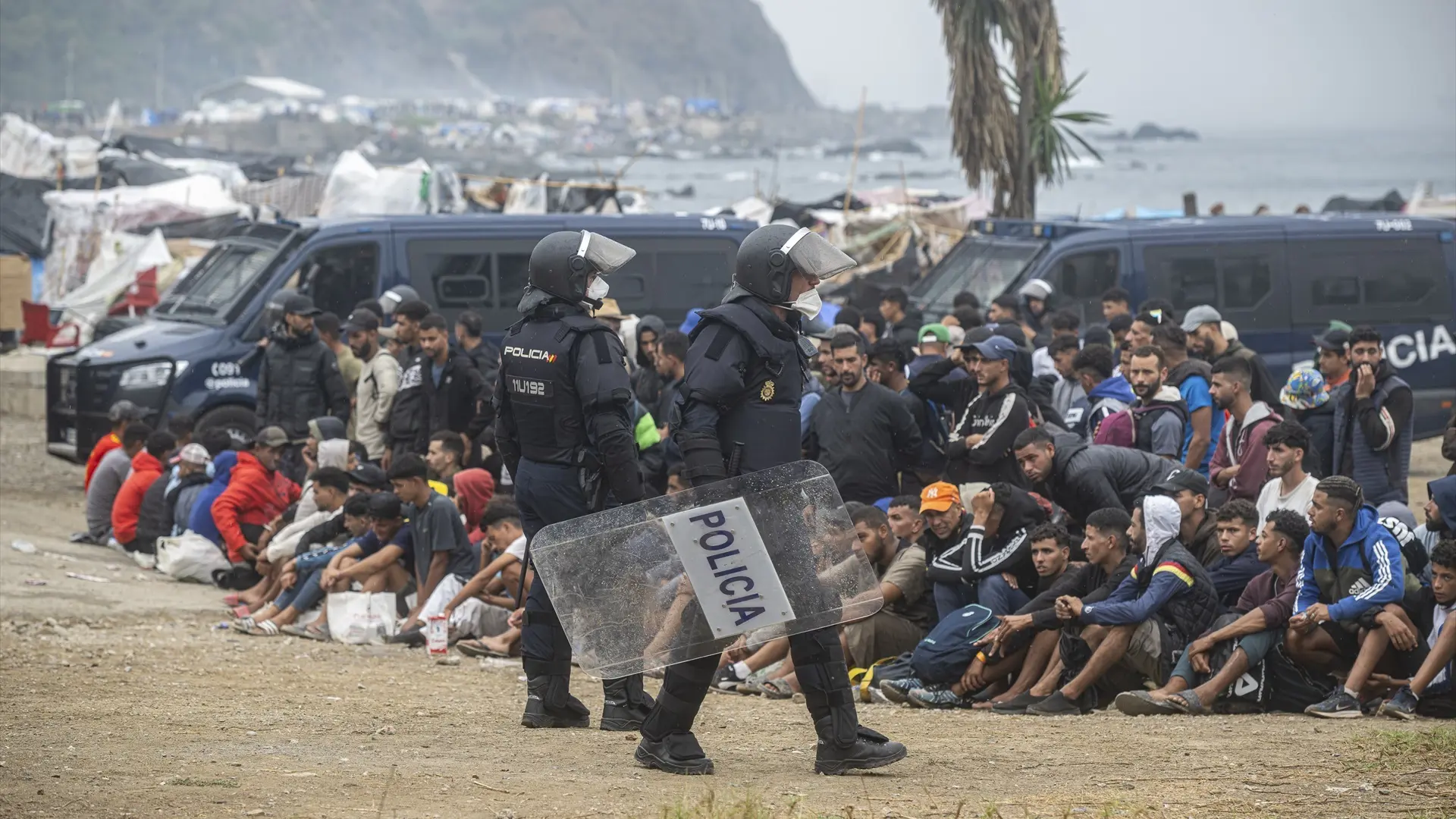 Agentes de la Policía Nacional intervienen durante el proceso de desalojo del embolsamiento de migrantes en la playa de El Tr