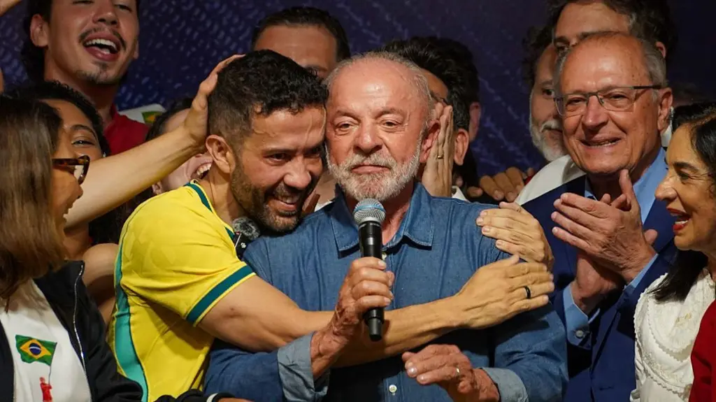 El presidente de Brasil, Luiz Inácio Lula da Silva, vestido con una camisa vaquera y sosteniendo un micrófono, pronuncia un d
