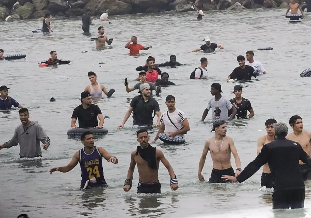 Un grupo de inmigrantes en la playa junto al paso fronterizo del Tarajal en Ceuta Un grupo de inmigrantes en la playa junto a