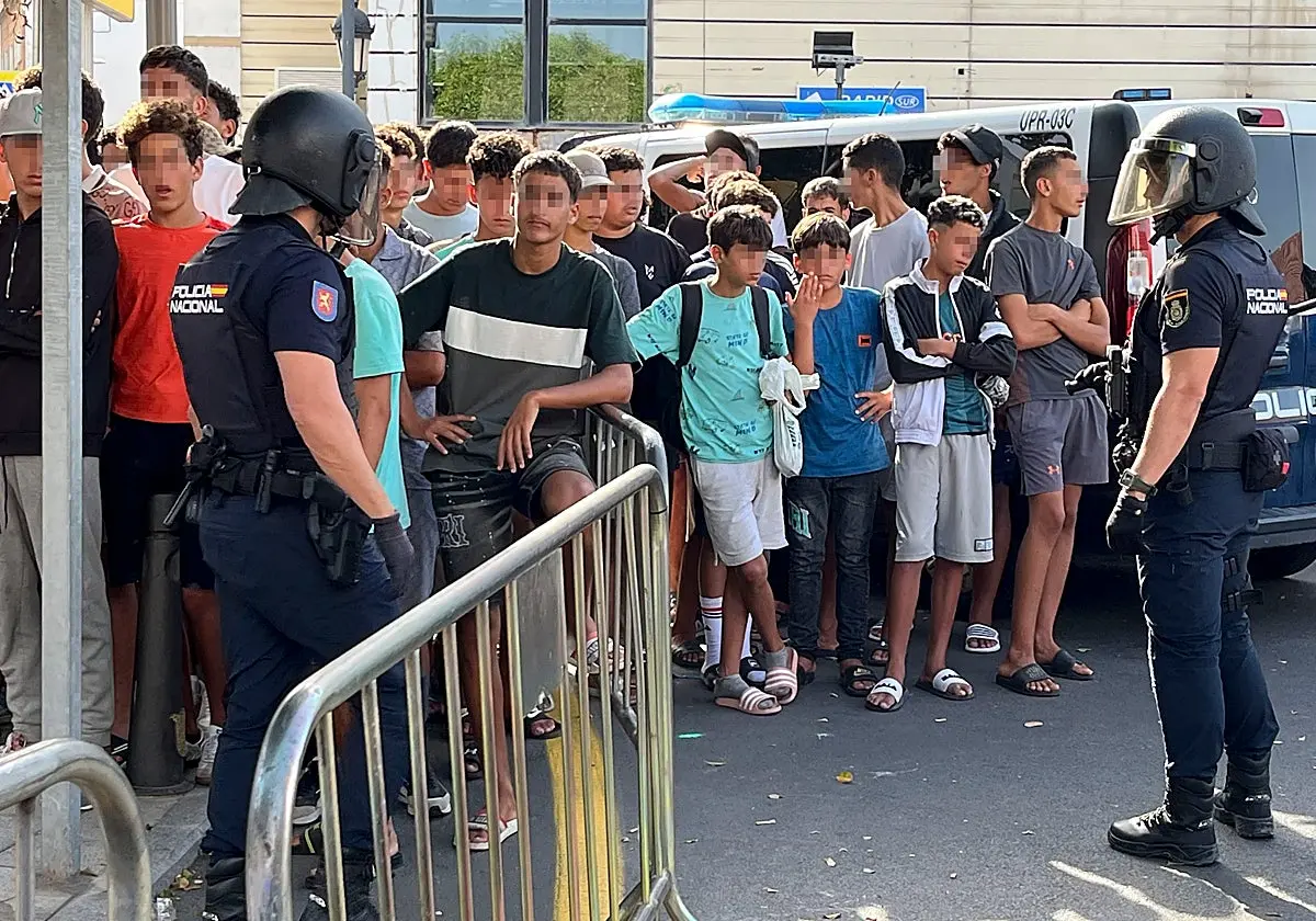 Agentes de la Policía Nacional con inmigrantes en Ceuta. Agentes de la Policía Nacional con inmigrantes en Ceuta. (EFE)