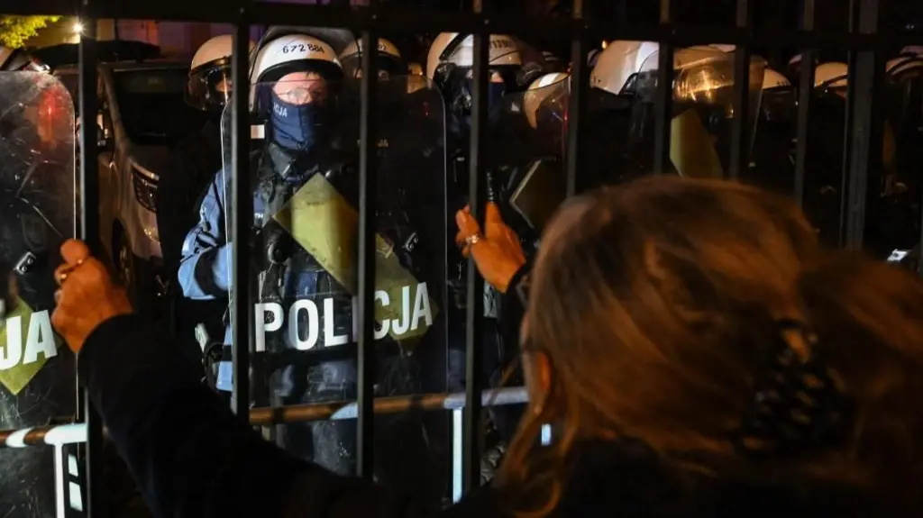 Una mujer observa a los agentes de policía que montan guardia frente al Tribunal Constitucional de Polonia en Varsovia. Foto: